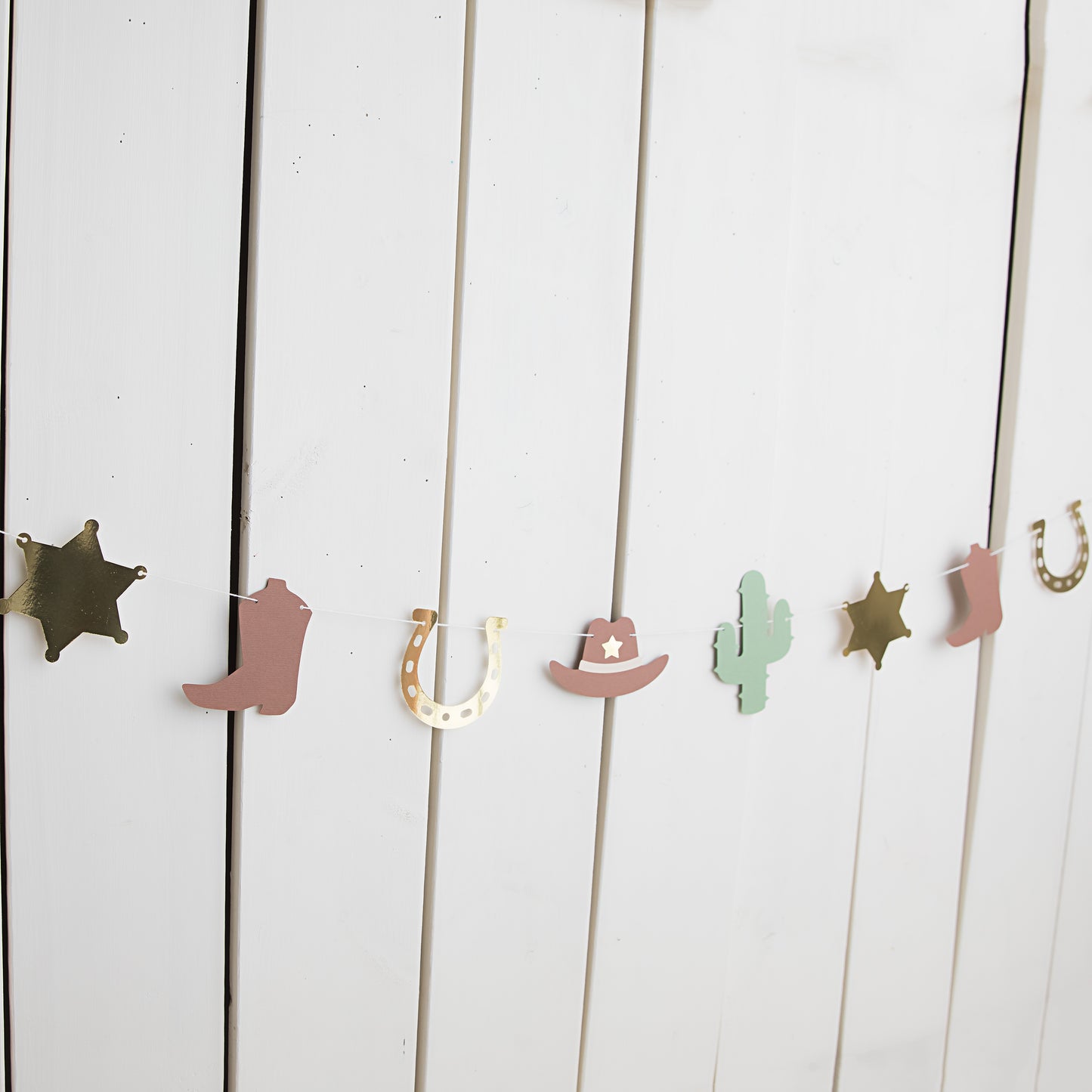 My first rodeo paper garland with cowboy boots, sheriff badges, cacti and cowboy hats